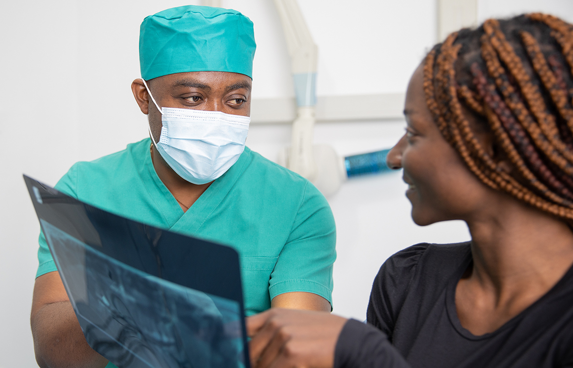 A dentist shows x-rays to his patient, African dental clinic.